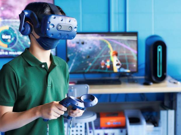 a young student wearing VR headset holding controllers