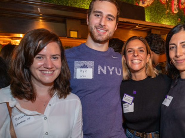 smiling students wearing name tags at an event off campus