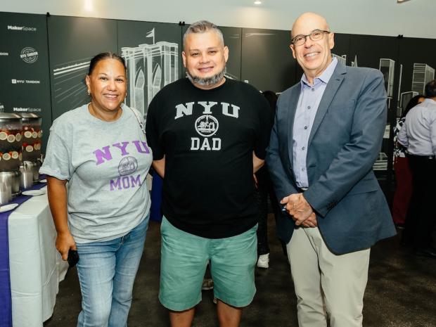 parents wearing NYU Mom and Dad sweatshirts with the Dean de Pablo