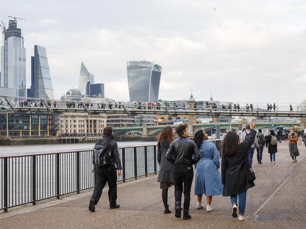 group of students walking along the riverfront in London
