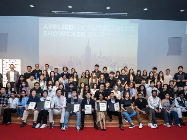 Urban Data Science Class of 2025 sitting on the stage of Pfizer Auditorium