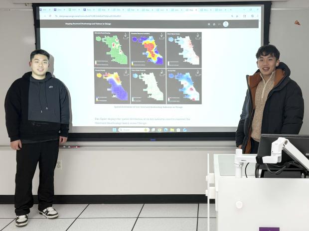 Guanyu Chen and Shangyu Yang smiling in front of a projected map of Chicago