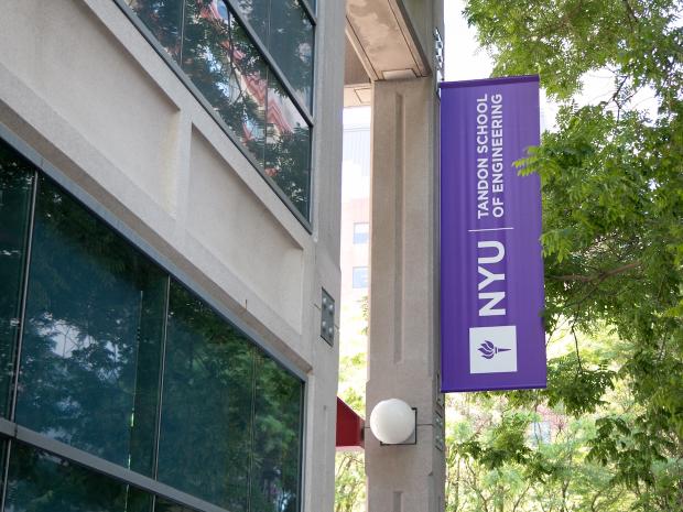 A purple Tandon banner afixed o a building on campus