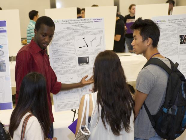 Student presenter at Poster session with three onlookers