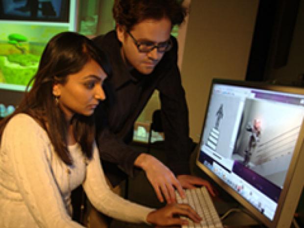 man helping a woman designing a game on a computer