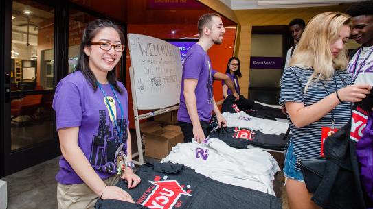 Orientation leaders hand out t-shirts to the class of 2022.