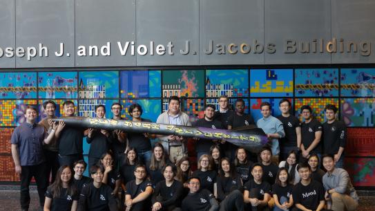 An image of students of Rogue Aerospace standing around their rocket creation