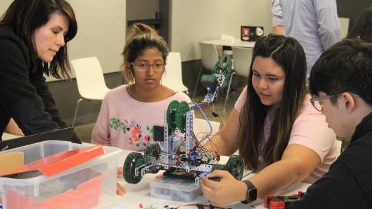 high school students working on a robot
