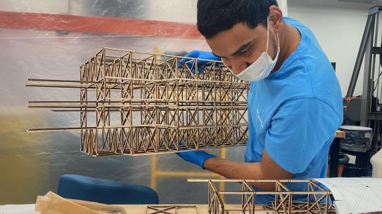Team member carrying a component of 2023 structure during assembly work