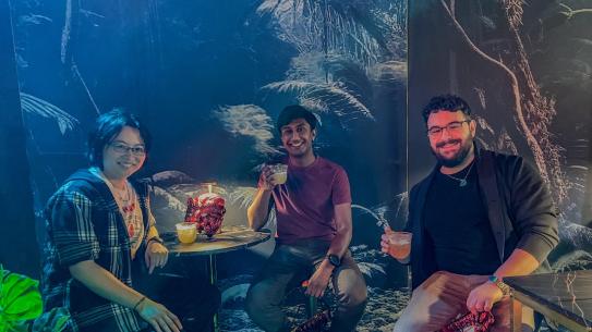 Group of students sitting in an immersive game room with themed visuals.