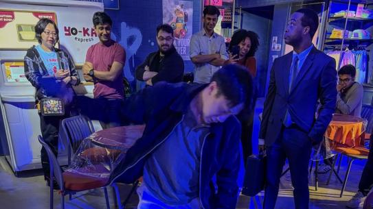 Students playing a rhythm or motion-based game under blue lighting.