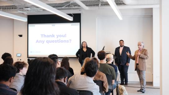 People in a room listening to a speech