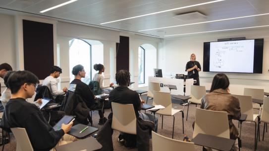 about a dozen students listening to lecture in classroom