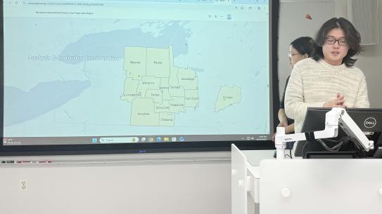 Flandre Dong, Fangqi Chen, and Han Xiao speaking in front of a map of New York