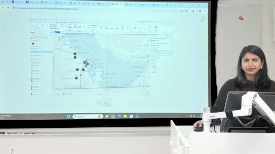 Ritika Lal speaking in front of a map of Saudi Arabia