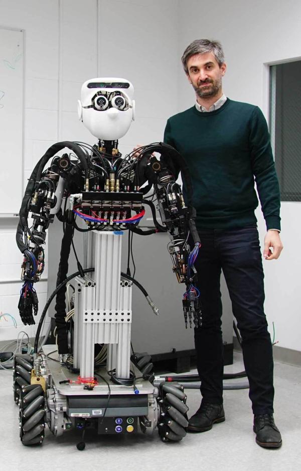 Man standing next to robot