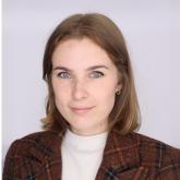 Picture of Faith Adams wearing a white turtleneck and brown blazer coat.