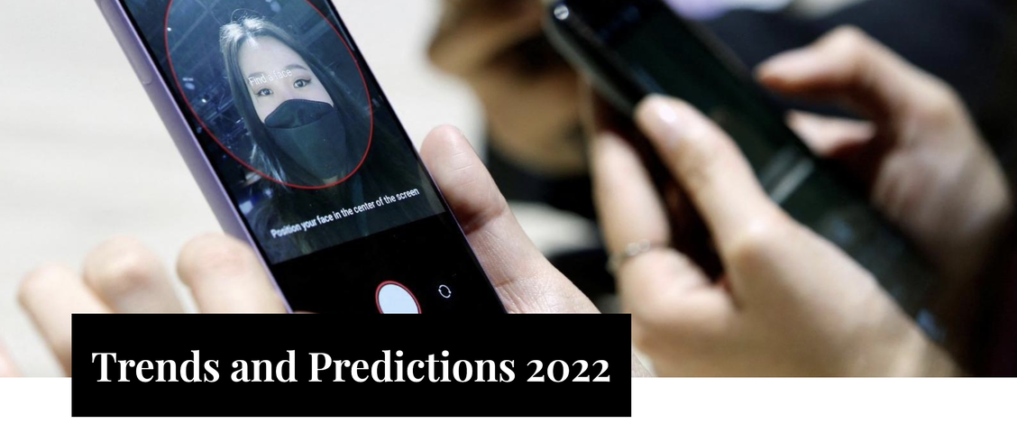 A person setting up the face recognition in their phone. There also some text saying: "Trends and Predictions 2022"
