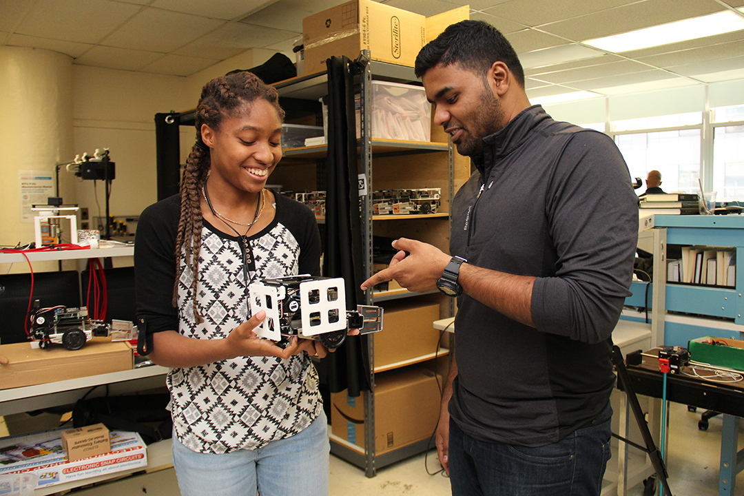 student holding a device in a tech lab