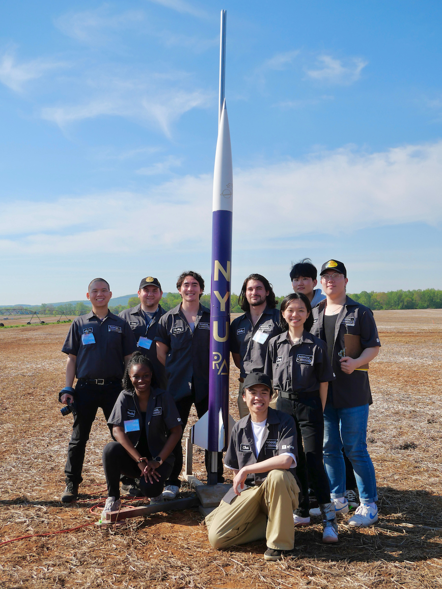 Rogue Aerospace team posing outside with rocket